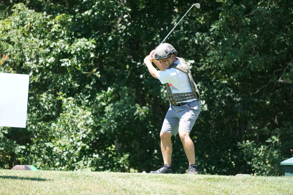 Person teeing off on golf course.