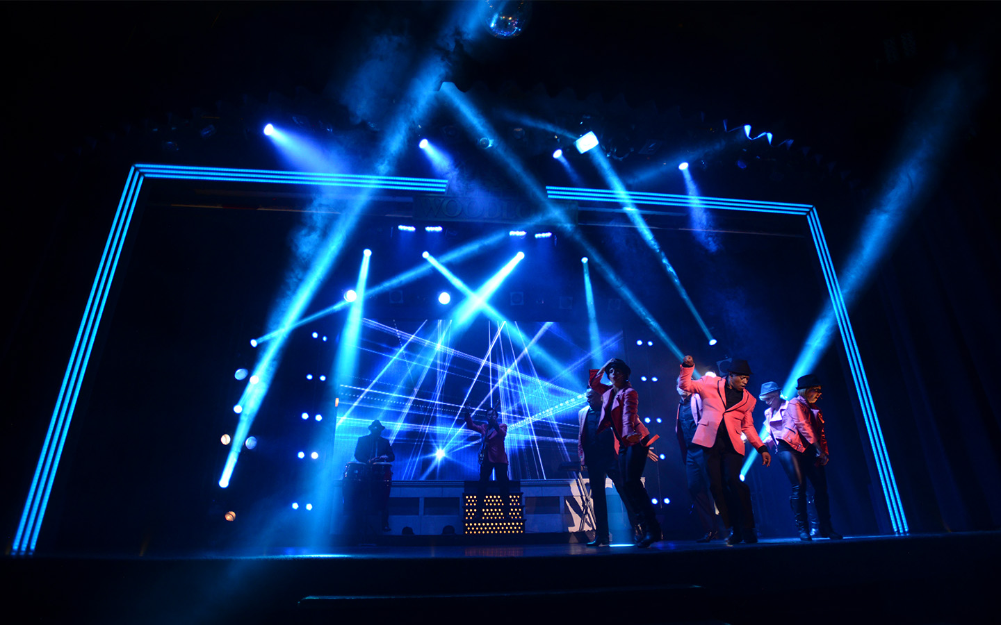 Singers in suits on stage.