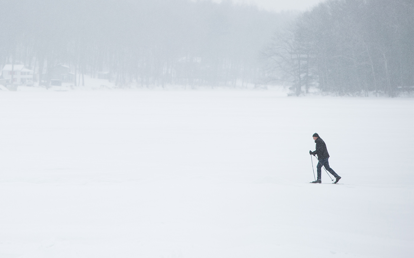 Person snowshoeing across Lake Teedyuskung in winter snow