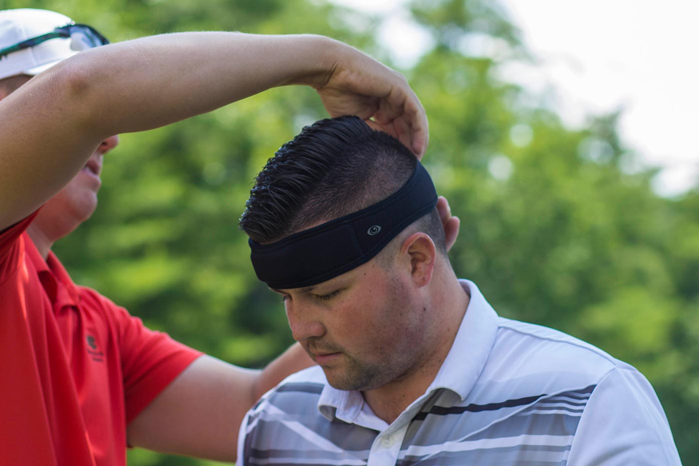 Golfer with monitor sweatband on their head.