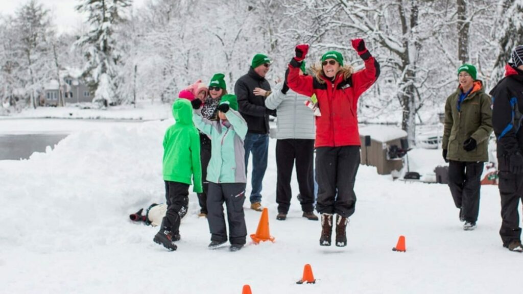 Woman cheering in snow with a winter family reunion.