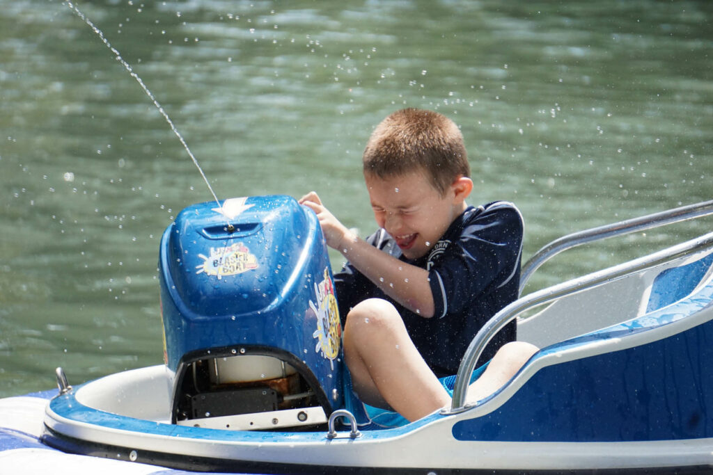 A kid on a bumper boat, one of the best finds when researching what to do in the Poconos in the summer.