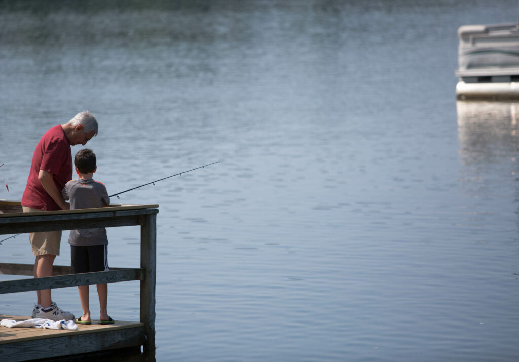 Two people fishing on a dock at a Pocono Mountains resort.