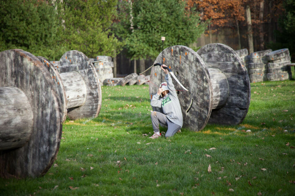 A person playing an archery game, one of the best Poconos activities in the summer.