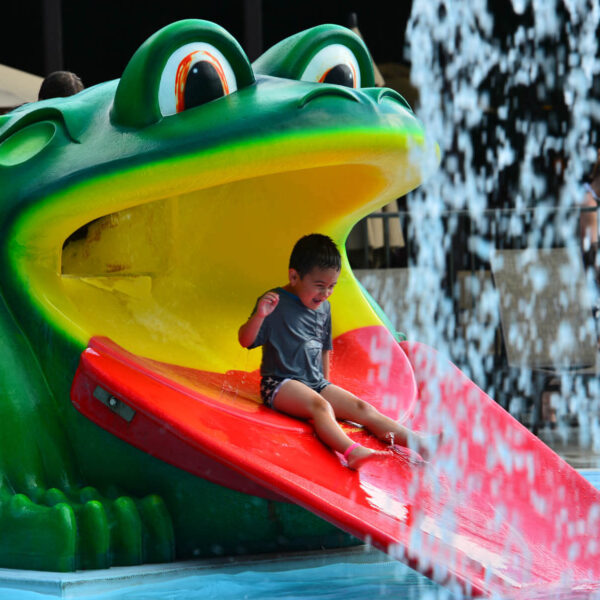 A kid going down a waterslide, one of the best family activities at our Poconos resort.