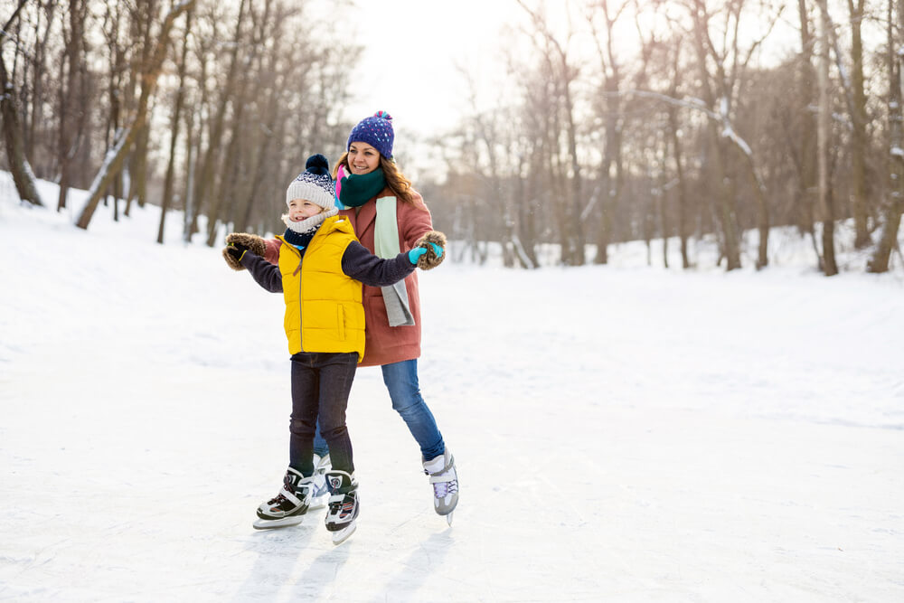 A mom and child ice skating at one of the winter attractions in the Poconos.